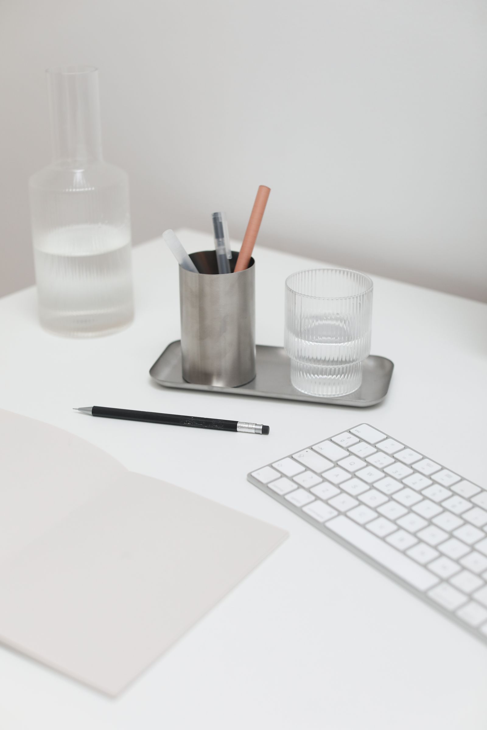Modern office desk with keyboard, notepad, and supplies